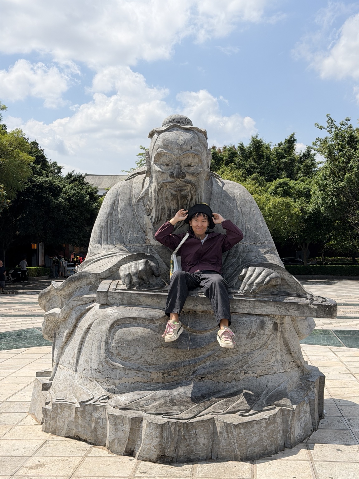 Xiabing Ruan in front of a stone statue